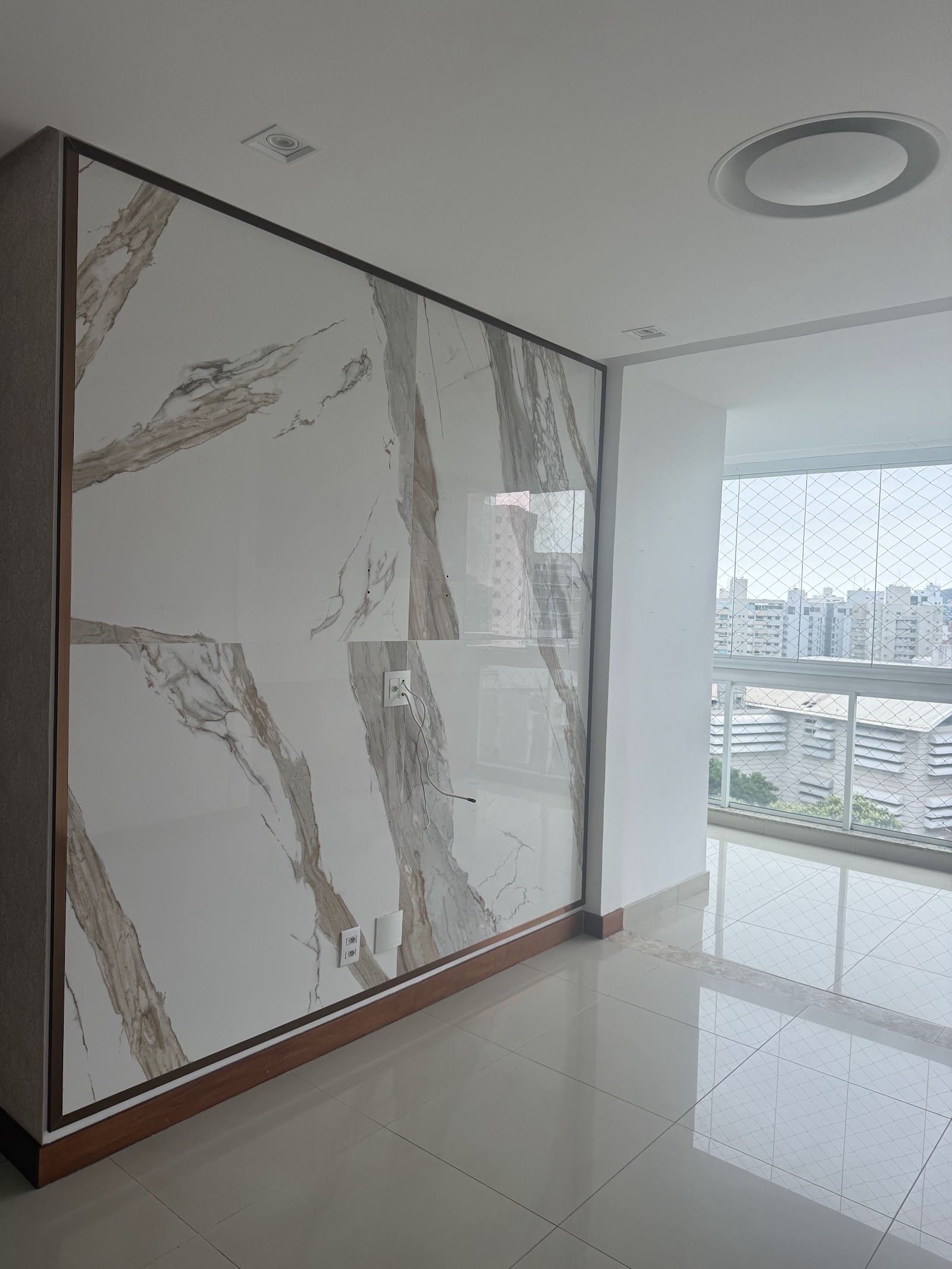 Detalhe do revestimento em porcelanato marmorizado da sala